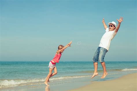 Pai E Filha Que Jogam Na Praia No Tempo Do Dia Foto De Stock Imagem