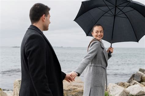 Tiro Medio Pareja Sonriente Cogidos De La Mano Foto Gratis