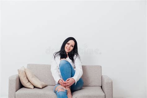 Beautiful Brunette Woman Sitting On Grey Sofa In White Room Stock Image Image Of Adult
