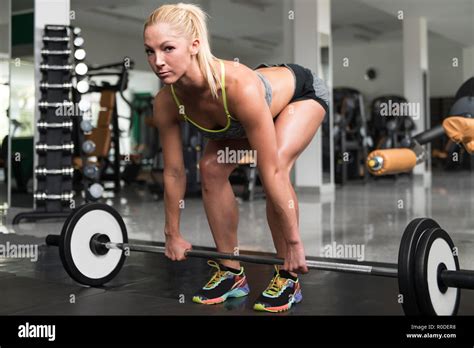 Mujer Joven El Ejercicio De Espalda Con Barbell En El Gimnasio Y