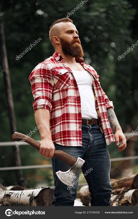 Bearded Lumberjack Worker Standing In Forest With Axe Stock Photo By