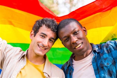 Premium Photo Portrait Of Multiethnic Gay Male Couple Holding A Rainbow Lgbt Symbol Flag
