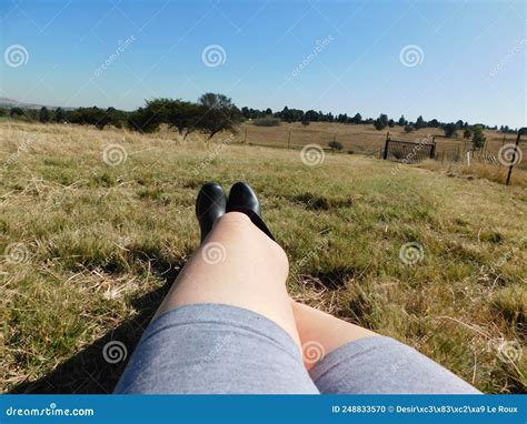 Caucasian Naked Legs Wearing Grey Shorts And Black Boots Legs Up One Foot On Knee Lying In A