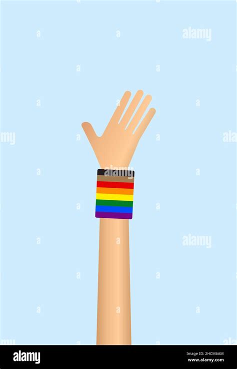 Main levée portant le bracelet drapeau arc en ciel gay Pride sur fond bleu Concept de fierté gay