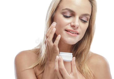 Beautiful Young Woman Smiling While Adding Facial Cream Stock Image