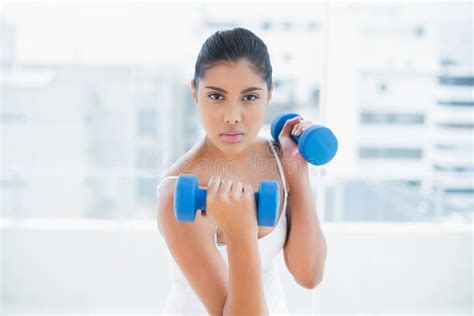Unsmiling Toned Brunette Holding Dumbbells Stock Image Image Of