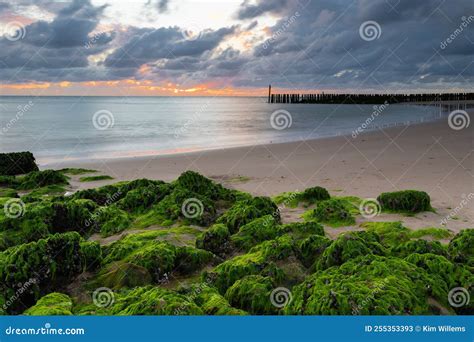 Um Dramático Pôr Do Sol Sobre Uma Praia Arenosa E O Mar Do Norte Nos