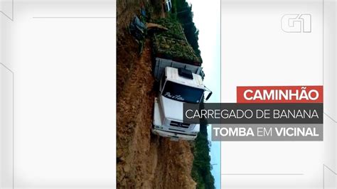 Caminhão carga de banana tomba ao passar por lama em estrada no