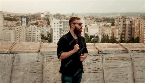 Premium Photo Serious Hipster Man Standing On Roof In City