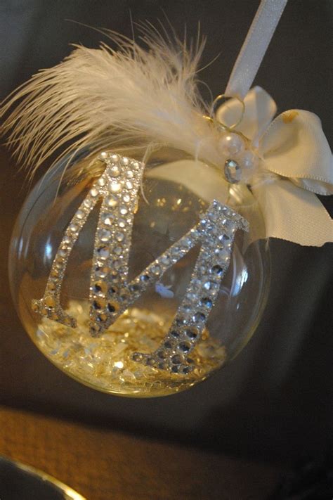 A Glass Ornament With The Letter N On It S Side And A White Ribbon