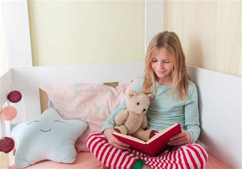 Petite Fille Blonde Livre De Lecture Fille Couchée Sur Un Lit Blanc Et Lecture Livre Avec Son