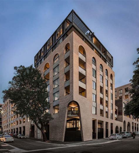 A Tall Brick Building Sitting On The Corner Of A Street