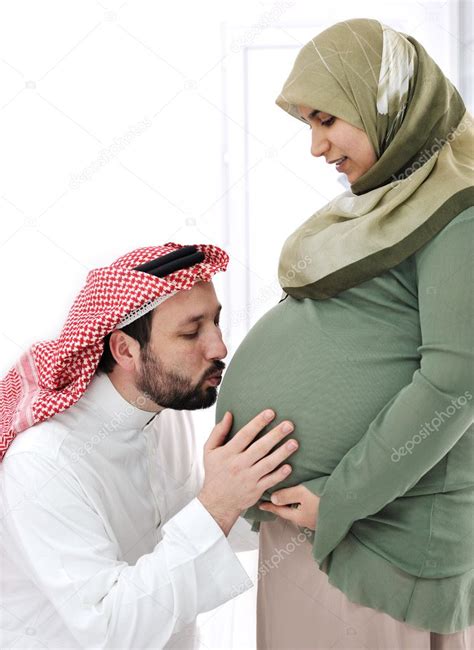 Pregnant Muslim Wife Smiling With Her Husband Kissing Belly And His