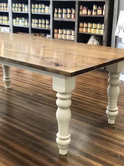 A Wooden Table Sitting On Top Of A Hard Wood Floor Next To Shelves