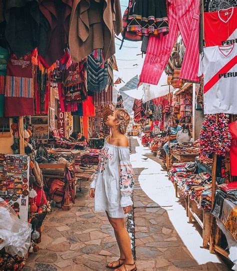 A Woman Standing In An Open Market Looking Up At The Clothes On Display