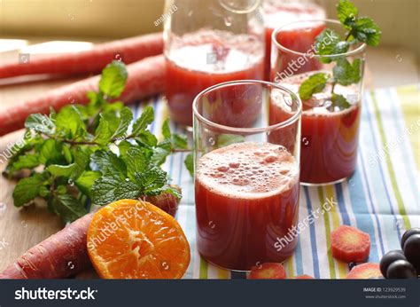 Fresh Red Carrot Juice Surrounded By Fresh Fruits And Vegetables And