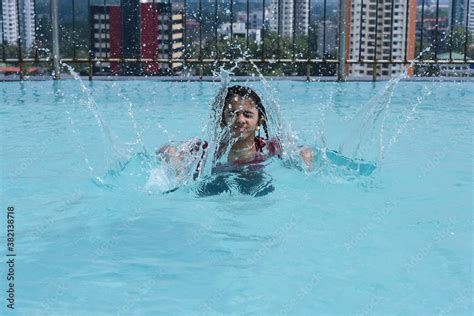 Small Indian Girl Swimming Or Learning To Swim Splashing Water In