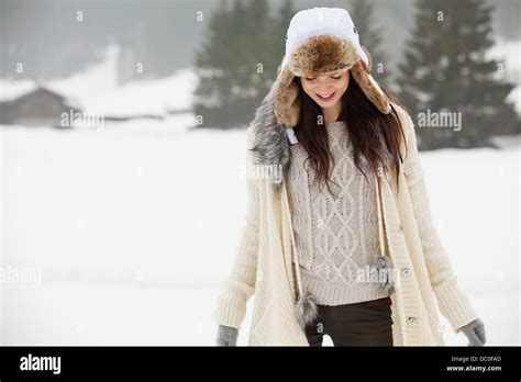 Smiling Woman Wearing Fur Hat In Snowy Field Stock Photo Alamy