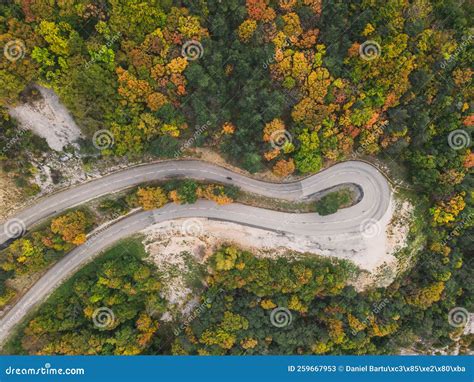 Aerial View Of A Winding Road From A High Mountain Pass Through A Dense