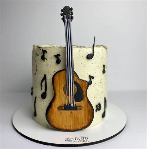 A Cake Decorated With Music Notes And A Guitar On It S Side Sitting On