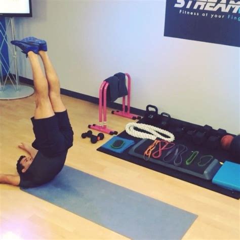 Two People Doing Yoga Exercises On Mats In A Room With Exercise