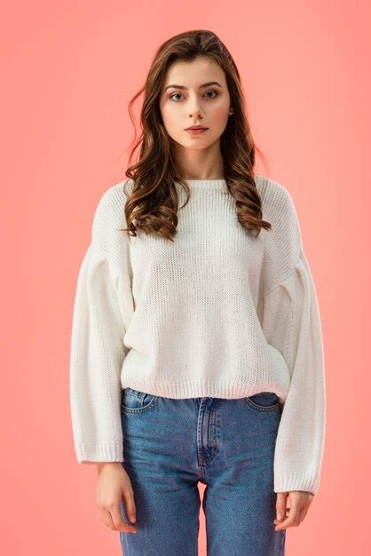 Premium Photo Brunette And Attractive Woman In White Sweater Looking At Camera Isolated On Pink