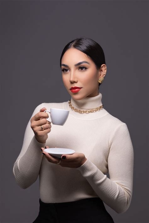 A Woman Holding A Cup And Saucer In Her Hands