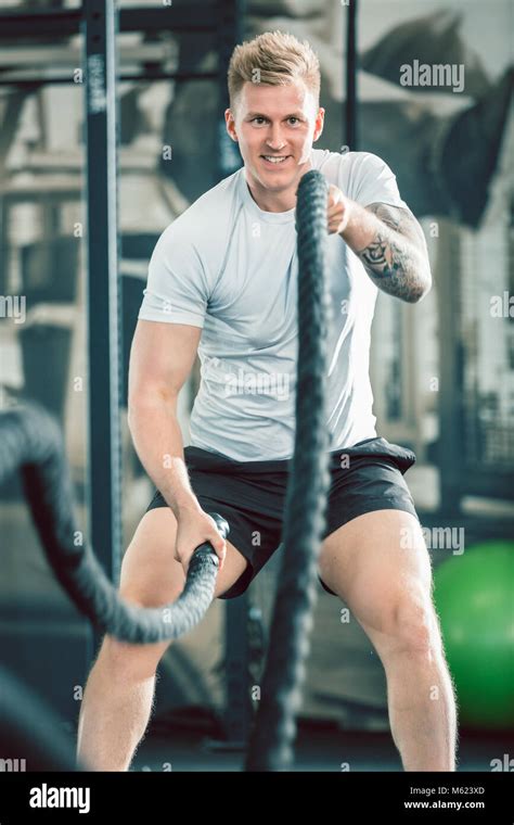 Handsome Bodybuilder Exercising With Battle Ropes During Functional