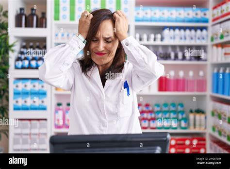 Middle Age Brunette Woman Working At Pharmacy Drugstore Suffering From