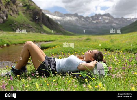 Full Body Side View Portrait Of A Hiker Resting In The Mountain On