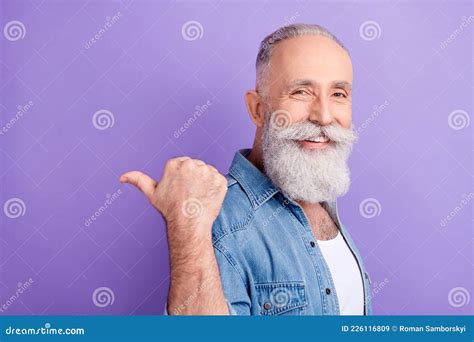 Photo Of Positive Sweet Age Gentleman Wear Jeans Shirt Pointing Back Finger Empty Space Isolated