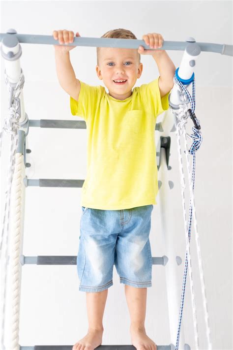 Heureux Petit Garçon En Bonne Santé Fait Du Sport Sur Le Mur Suédois De