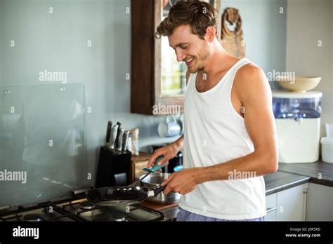 Happy Man Cooking Food In Kitchen Stock Photo Alamy