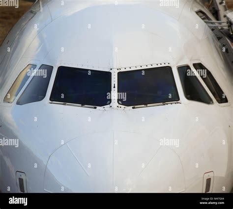 Close up of the front of a passenger jet showing the cockpit windows ...