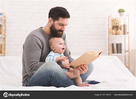 Father reading book to little baby son Stock Photo by ©Milkos 231130472