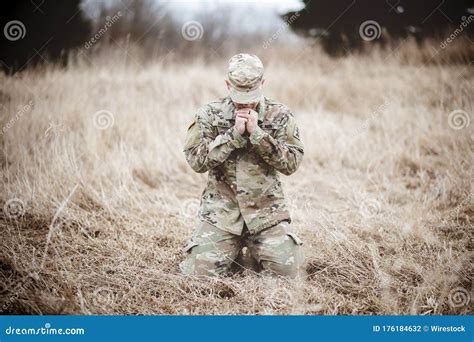 Shallow Focus Shot Of An American Soldier Praying In A Field While