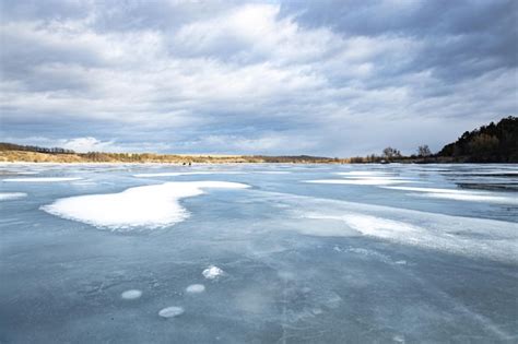 Paisagem de inverno em um rio congelado na geada pesada do pôr do sol e