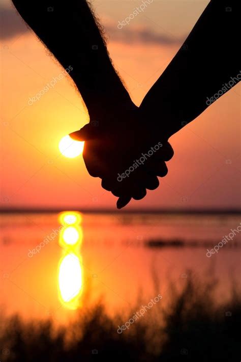 Couples In The Sunset Holding Hands