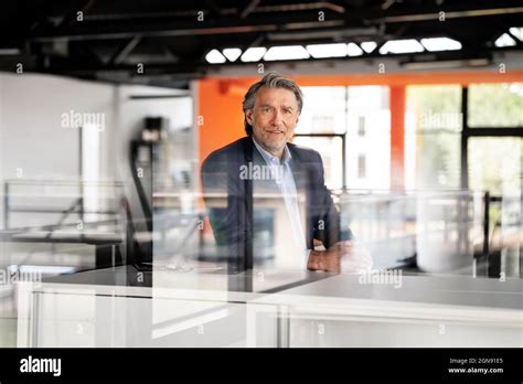 Mature Businessman Standing At Desk Stock Photo Alamy