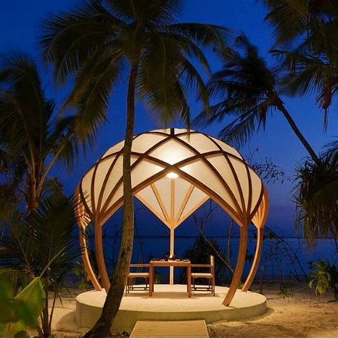 An Outdoor Gazebo Is Lit Up At Night With Palm Trees In The Foreground