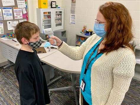 Nurses administering COVID tests at school, working with families ...