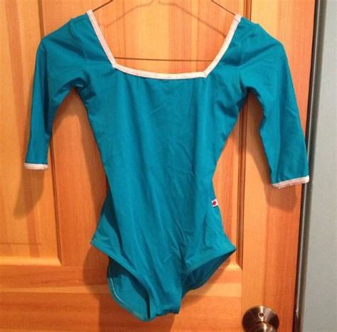 Yumiko Leotard Marieke With Sleeves In T Cyan With A V Silver Trim