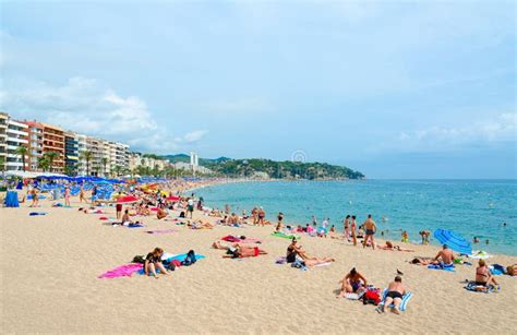 People Rest On Beach In Popular Resort Town Of Lloret De Mar Costa