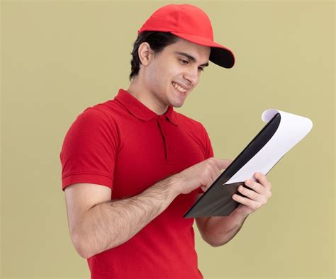 Repartidor Joven Sonriente En Uniforme Rojo Y Gorra De Pie En La Vista