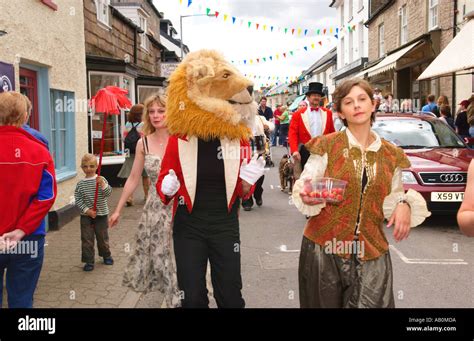 Performers from Giffords Circus in lion costumes parade on street as part of Hay Festival in Hay ...