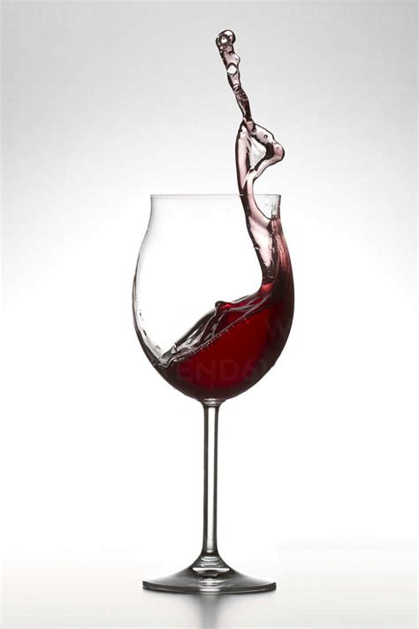 Red Wine Splashing In Glass On White Background Stock Photo