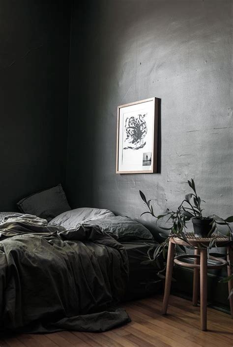 An Unmade Bed Sitting In A Bedroom Next To A Table And Potted Plant