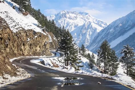 A Curvy Road Passing Through Snow Covered Mountains Of Himalayas At