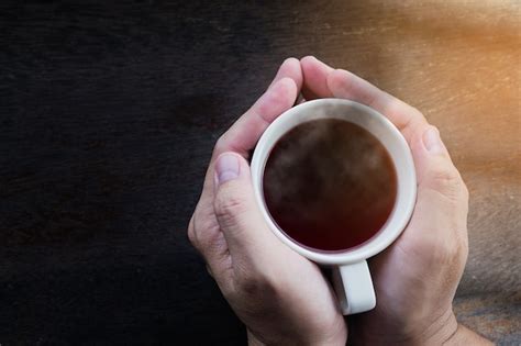 Free Photo Top View Of Man Hands Holding Hot Coffee Mug