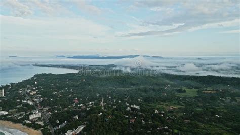 Sunrise Illuminates Mist Enshrouded Tropical Island From Aerial View